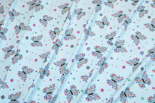 Vendita on line tessuto maglina cotone fantasia farfalle fondo azzurro - tessuti abbigliamento magline / jersey/tessuto in fantasia